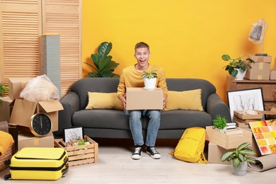 Photo of Happy man with different stuff in new apartment. Housewarming party