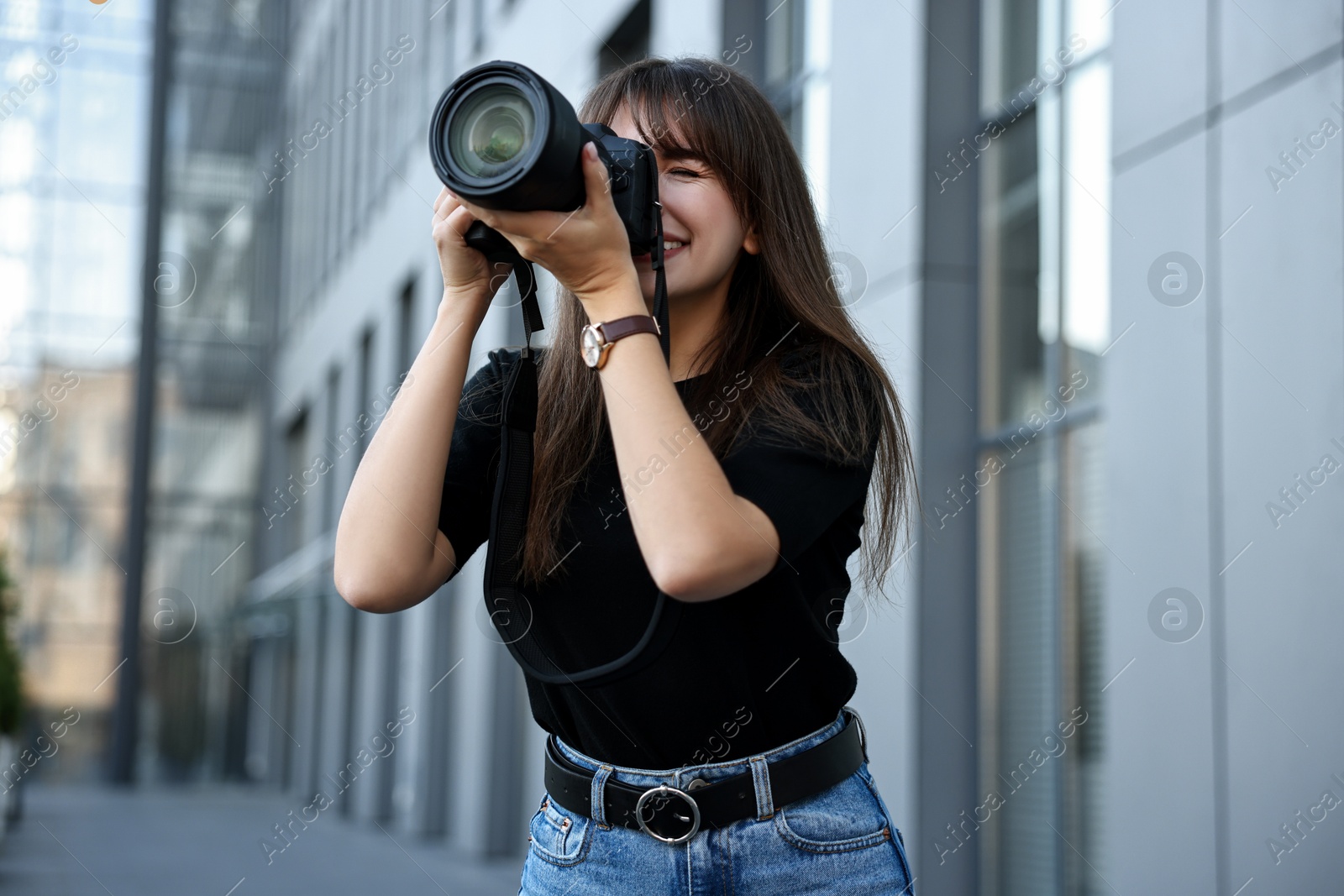 Photo of Professional photographer with digital camera near building outdoors