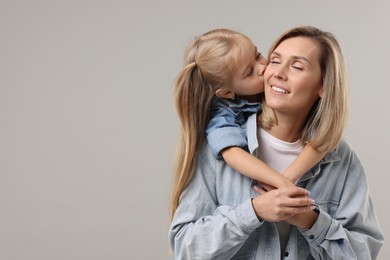 Photo of Cute little girl with her mom on gray background, space for text. Happy Mother's Day