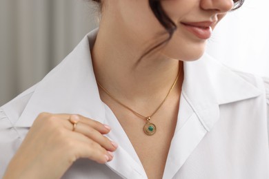 Photo of Woman wearing elegant ring and necklace indoors, closeup