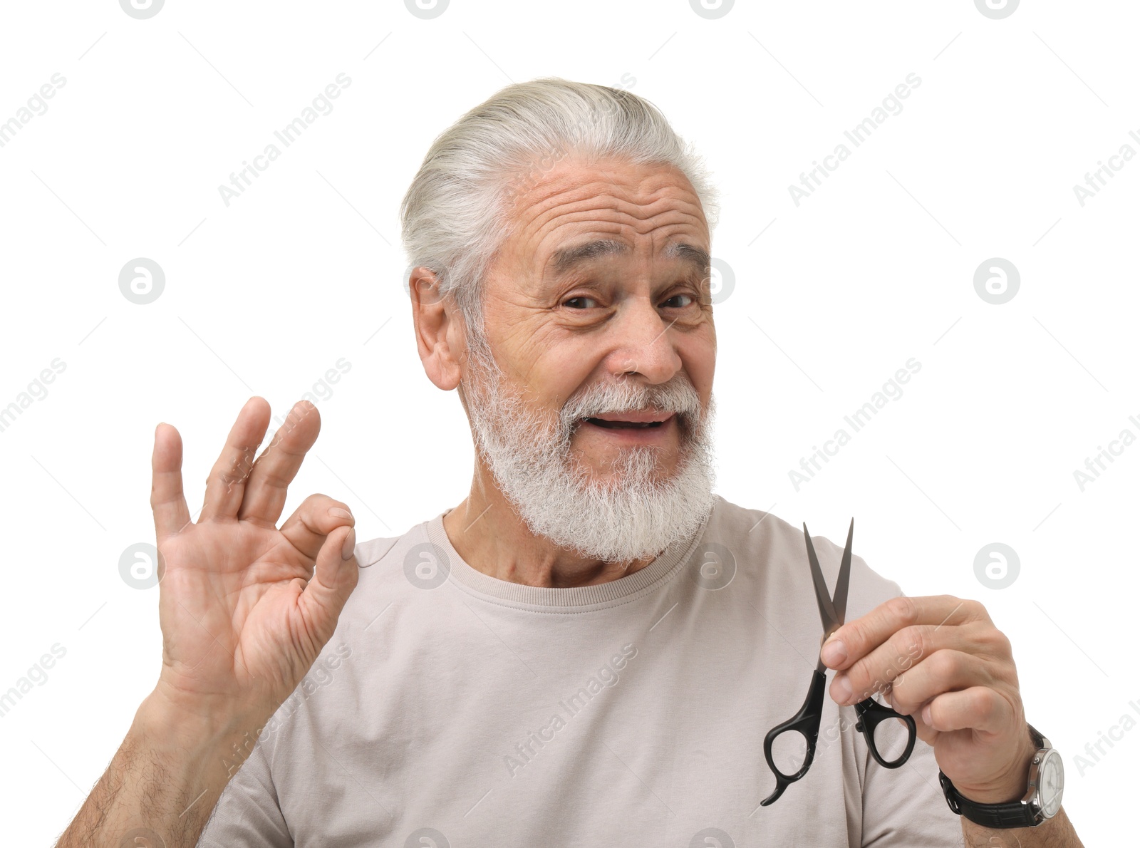 Photo of Bearded senior man with scissors showing ok gesture on white background