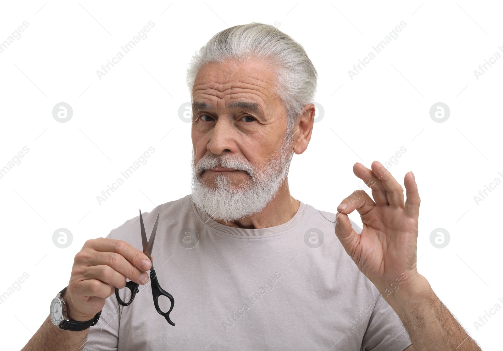 Photo of Bearded senior man with scissors showing ok gesture on white background