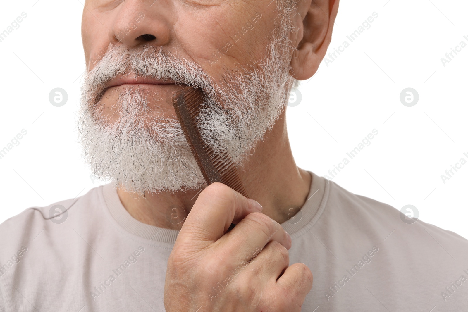 Photo of Senior man combing beard on white background, closeup