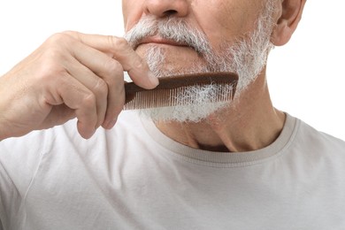 Photo of Senior man combing beard on white background, closeup