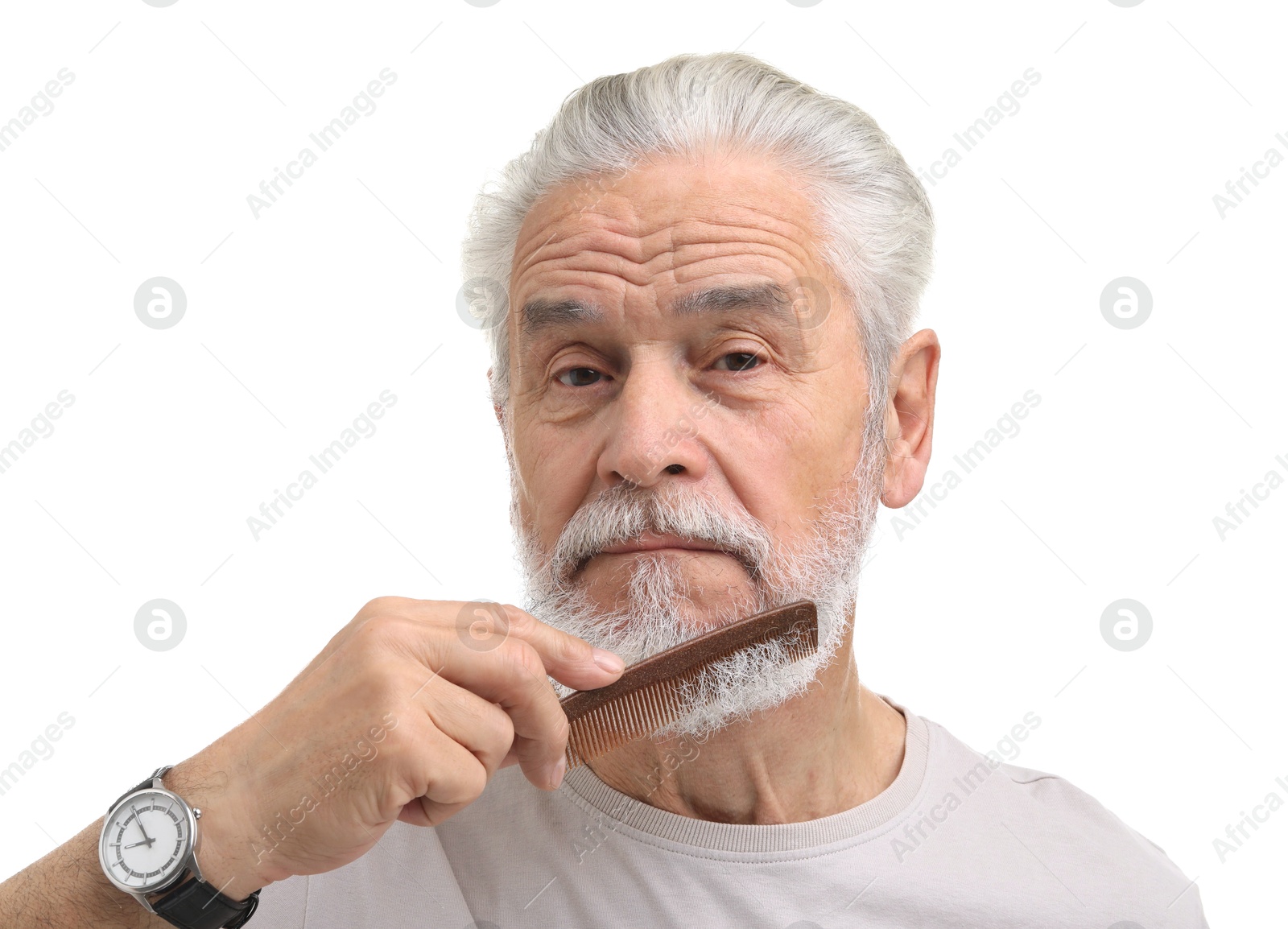 Photo of Senior man combing beard on white background