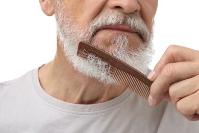 Senior man combing beard on white background, closeup