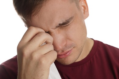 Photo of Crying man wiping tears with tissue on white background