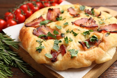 Photo of Delicious focaccia bread with bacon and parsley on wooden table, closeup