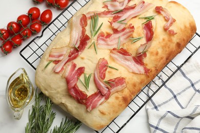 Photo of Delicious focaccia bread with bacon and rosemary on white table, flat lay