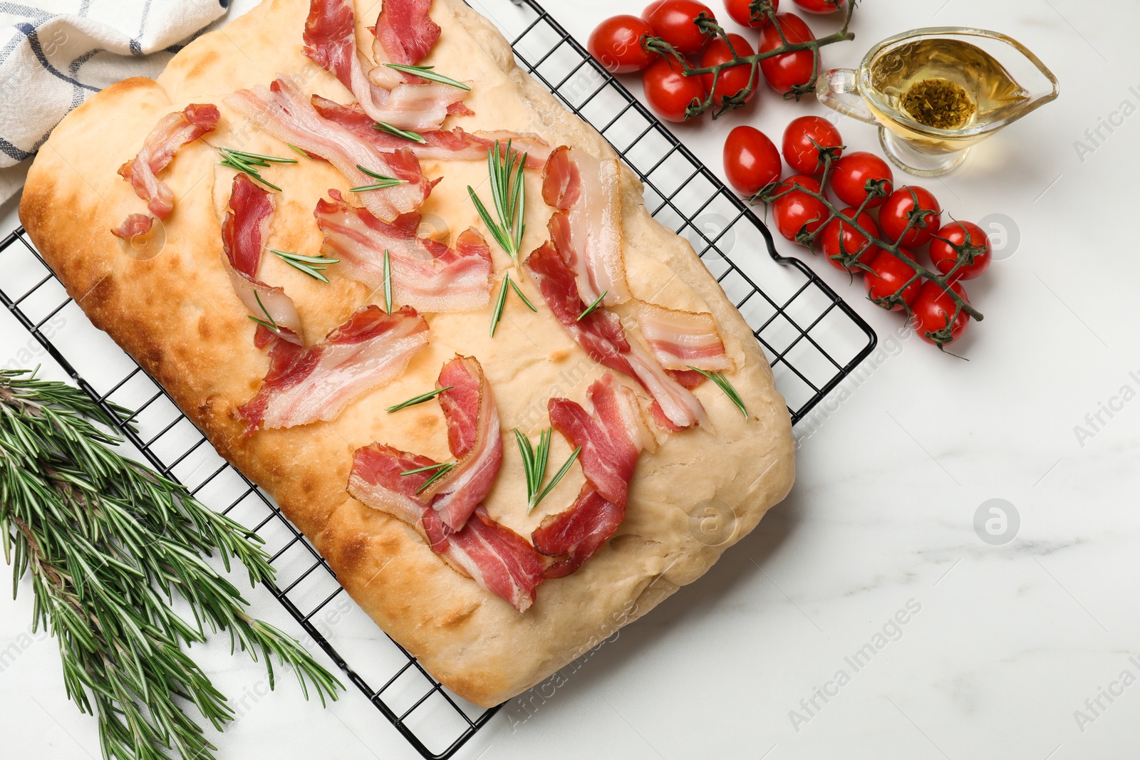 Photo of Delicious focaccia bread with bacon and rosemary on white table, flat lay