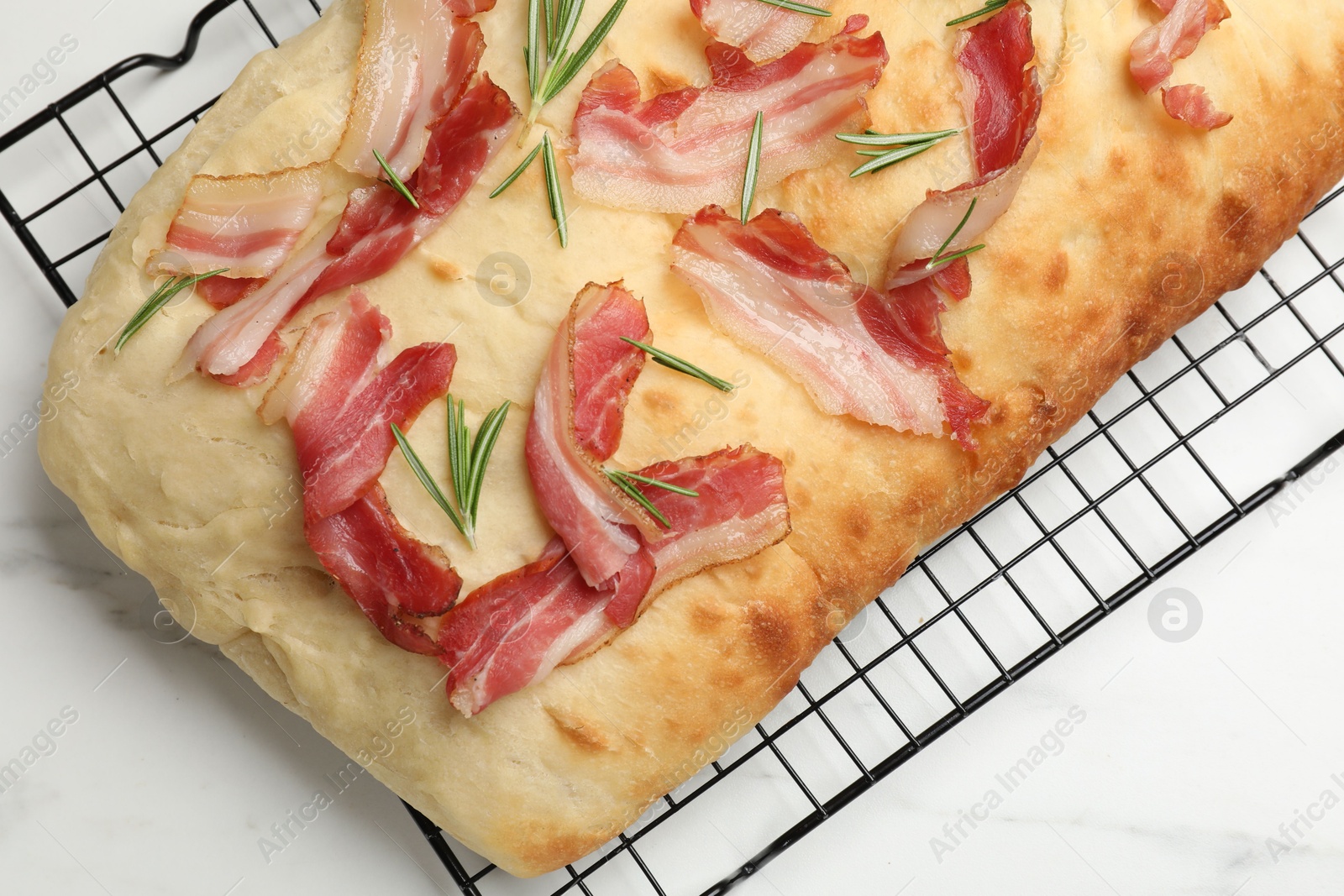 Photo of Delicious focaccia bread with bacon and rosemary on white table, top view