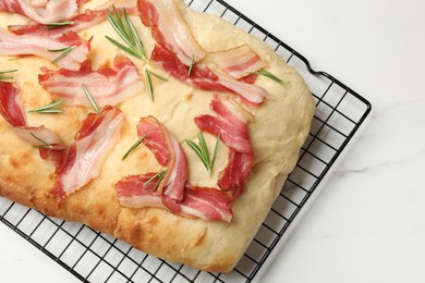 Photo of Delicious focaccia bread with bacon and rosemary on white table, top view