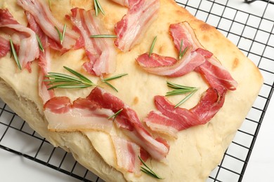 Photo of Delicious focaccia bread with bacon and rosemary on white table, top view