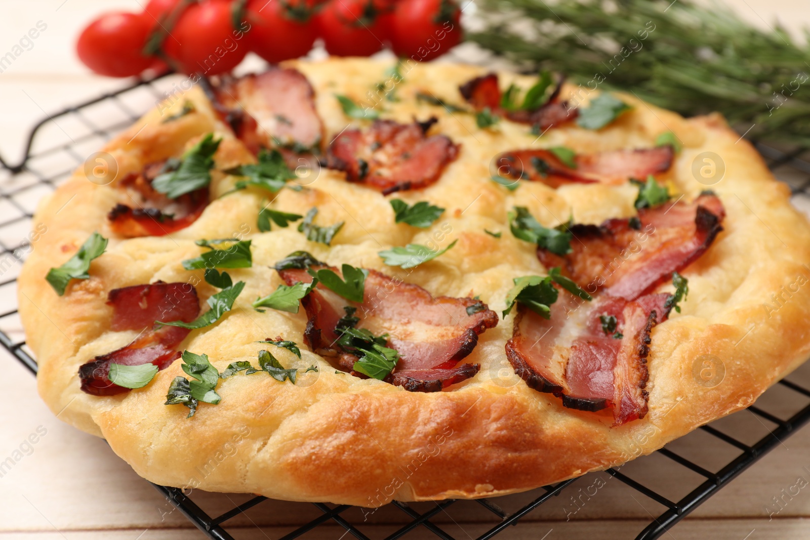 Photo of Delicious focaccia bread with bacon and parsley on white wooden table, closeup