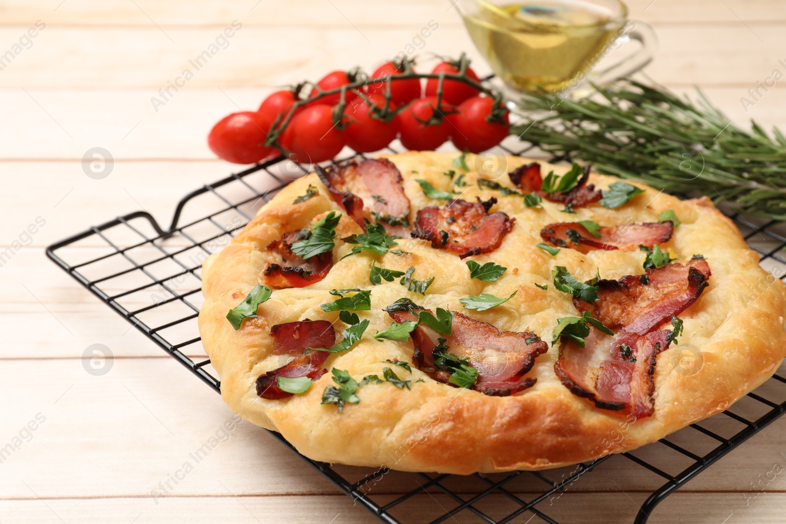 Photo of Delicious focaccia bread with bacon and parsley on white wooden table, closeup