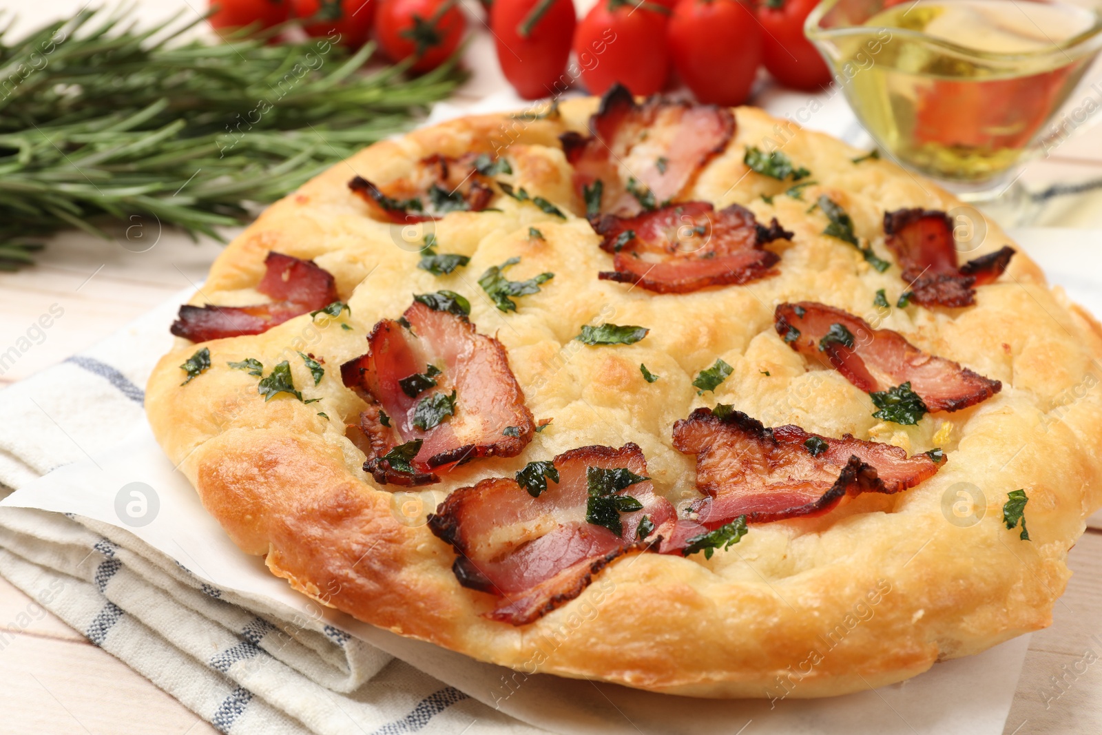 Photo of Delicious focaccia bread with bacon and parsley on white wooden table, closeup