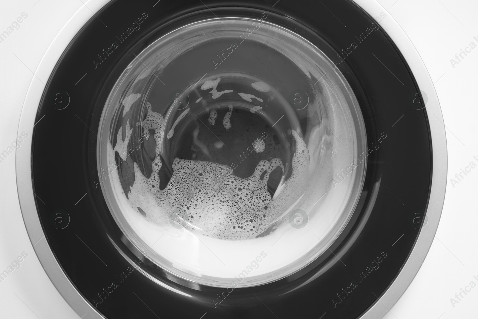 Photo of Washing machine with suds as background, closeup