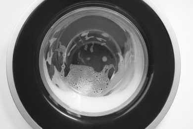 Photo of Washing machine with suds as background, closeup