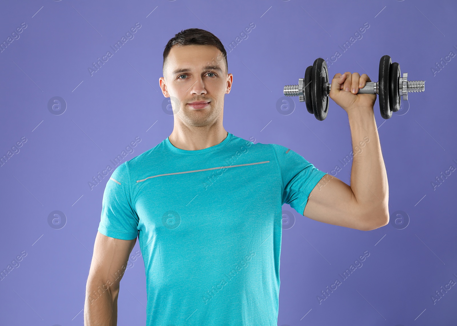 Photo of Man exercising with barbell on violet background