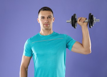 Photo of Man exercising with barbell on violet background