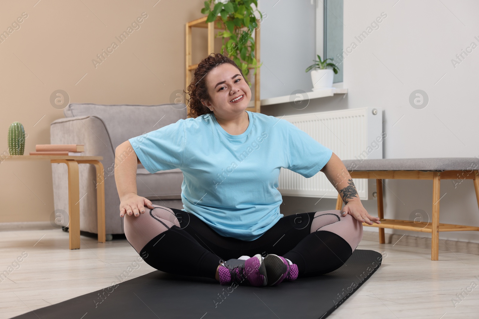 Photo of Woman in lotus position on fitness mat at home