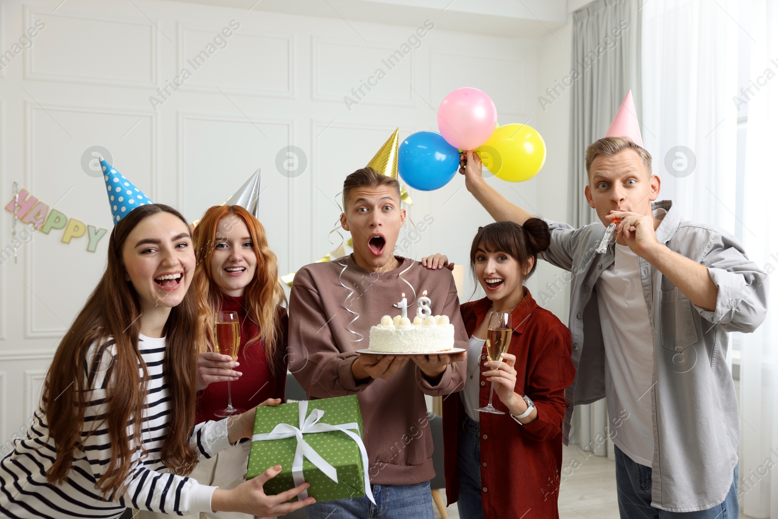 Photo of 18th birthday. Group of friends with tasty cake having coming of age party at home