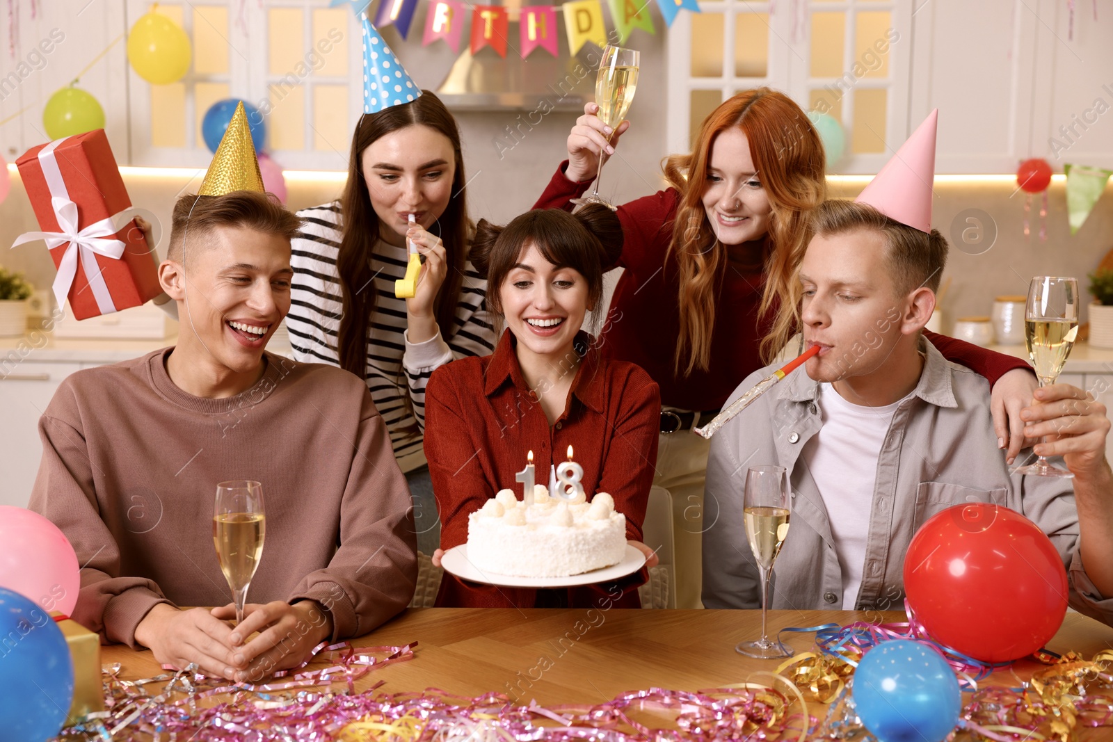 Photo of 18th birthday. Group of friends with tasty cake having coming of age party at home