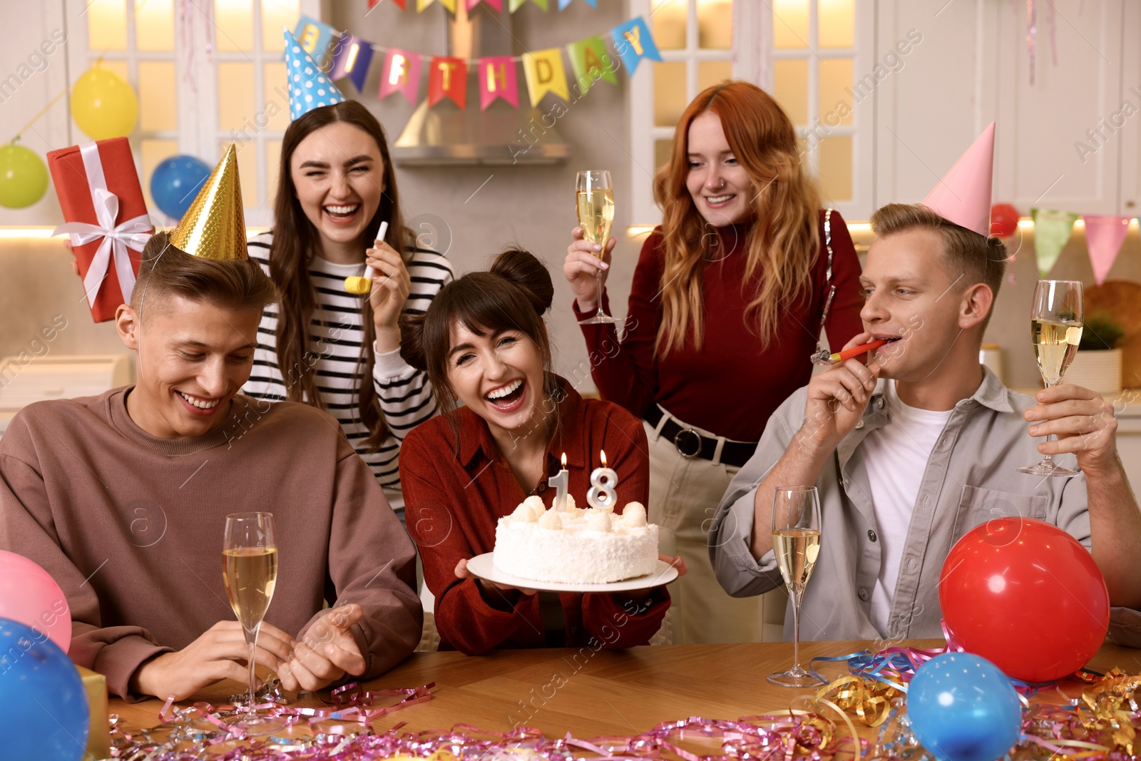 Photo of 18th birthday. Group of friends with tasty cake having coming of age party at home