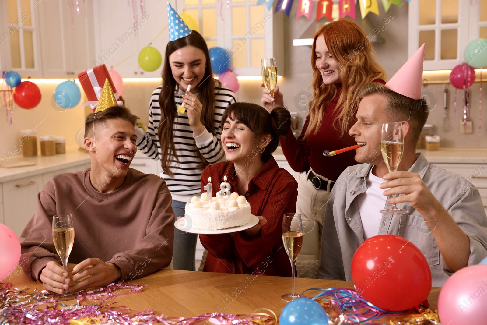 Photo of 18th birthday. Group of friends with tasty cake having coming of age party at home