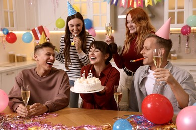 Photo of 18th birthday. Group of friends with tasty cake having coming of age party at home