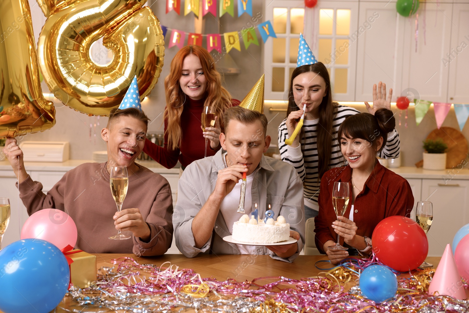 Photo of 18th birthday. Group of friends with tasty cake having coming of age party at home