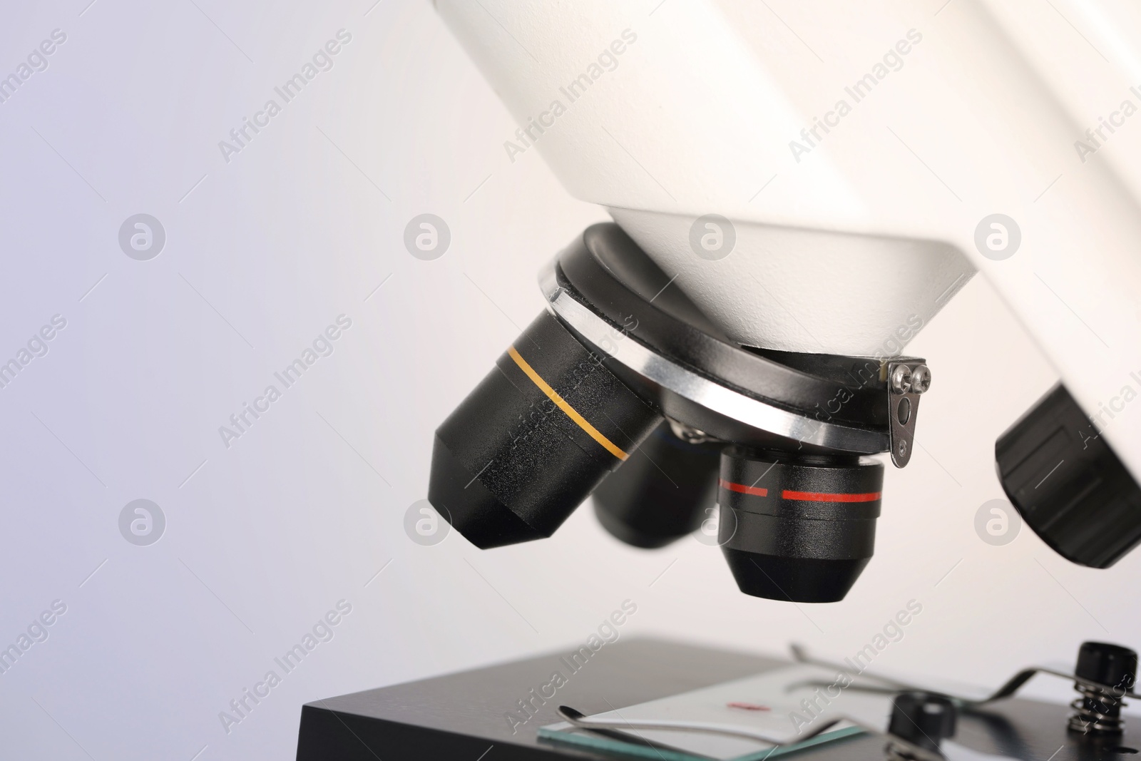 Photo of Science. Microscope with glass slide on light grey background, closeup. Space for text