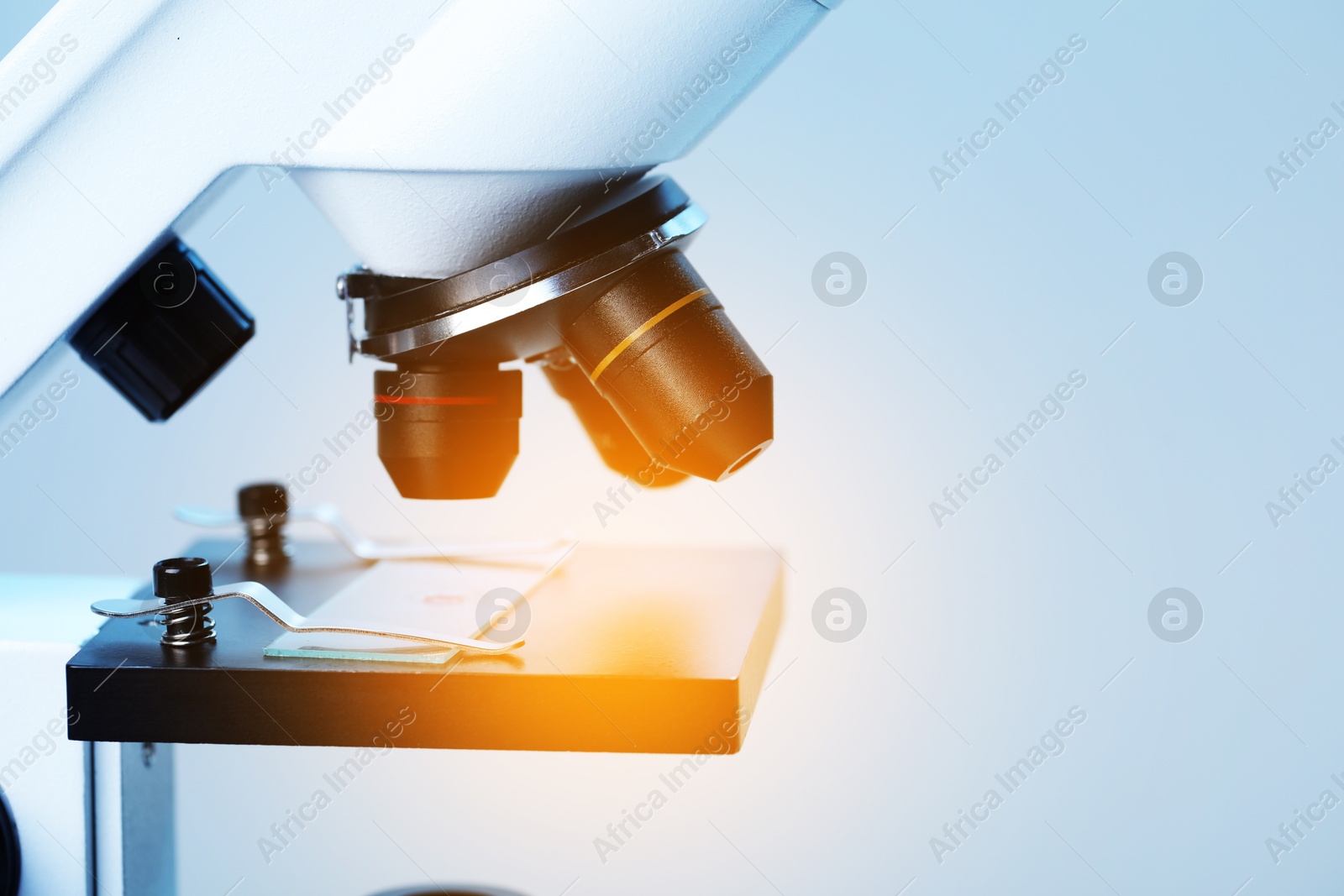 Photo of Science. Microscope with glass slide on light grey background, closeup. Space for text