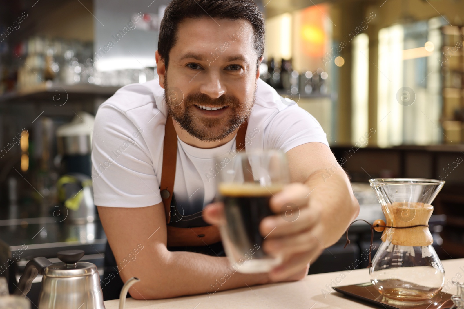 Photo of Barista suggesting cup of aromatic filter coffee in cafe, selective focus