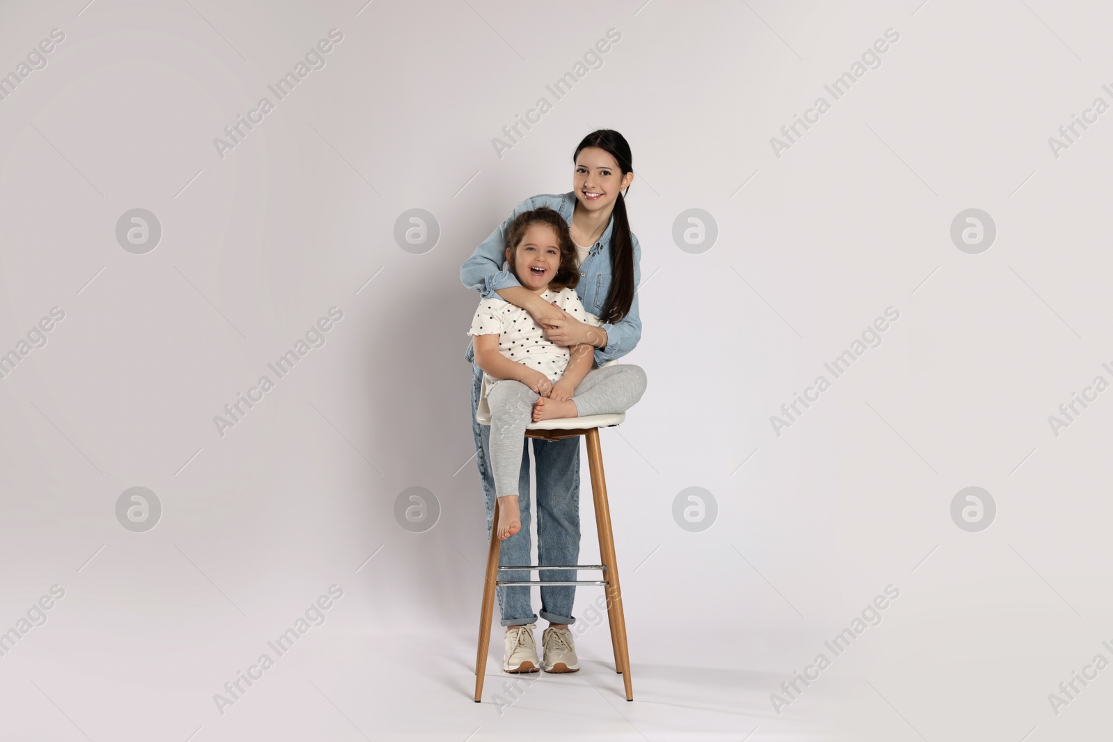 Photo of Portrait of cute sisters on white background