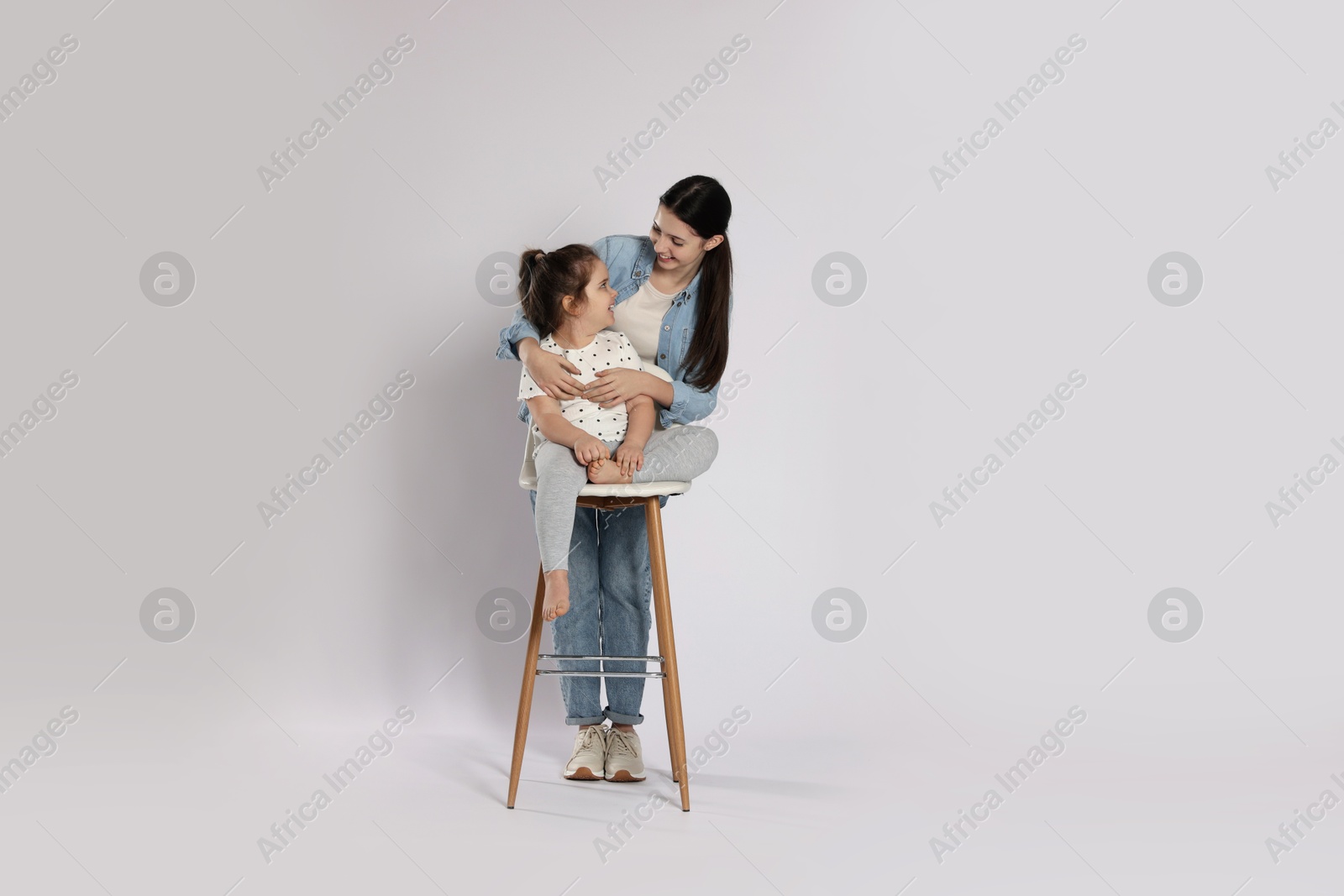 Photo of Portrait of cute sisters on white background