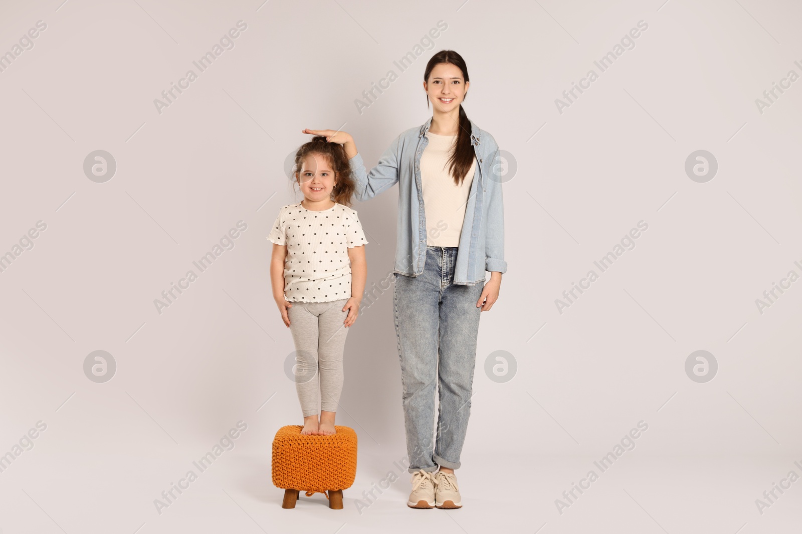 Photo of Full length portrait of cute sisters on white background