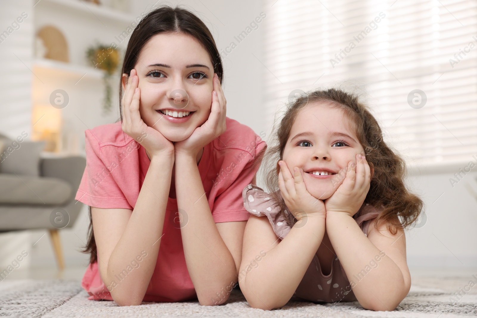 Photo of Portrait of cute little girl and her sister indoors