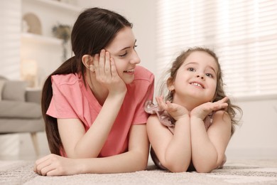 Photo of Portrait of cute little girl and her sister indoors