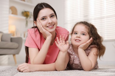 Photo of Portrait of cute little girl and her sister indoors