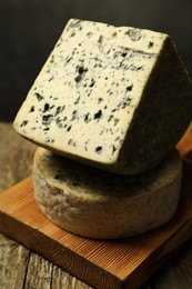 Photo of Fresh cheese on wooden table against grey background, closeup