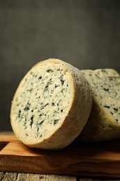 Photo of Fresh cheese on wooden table against grey background, closeup