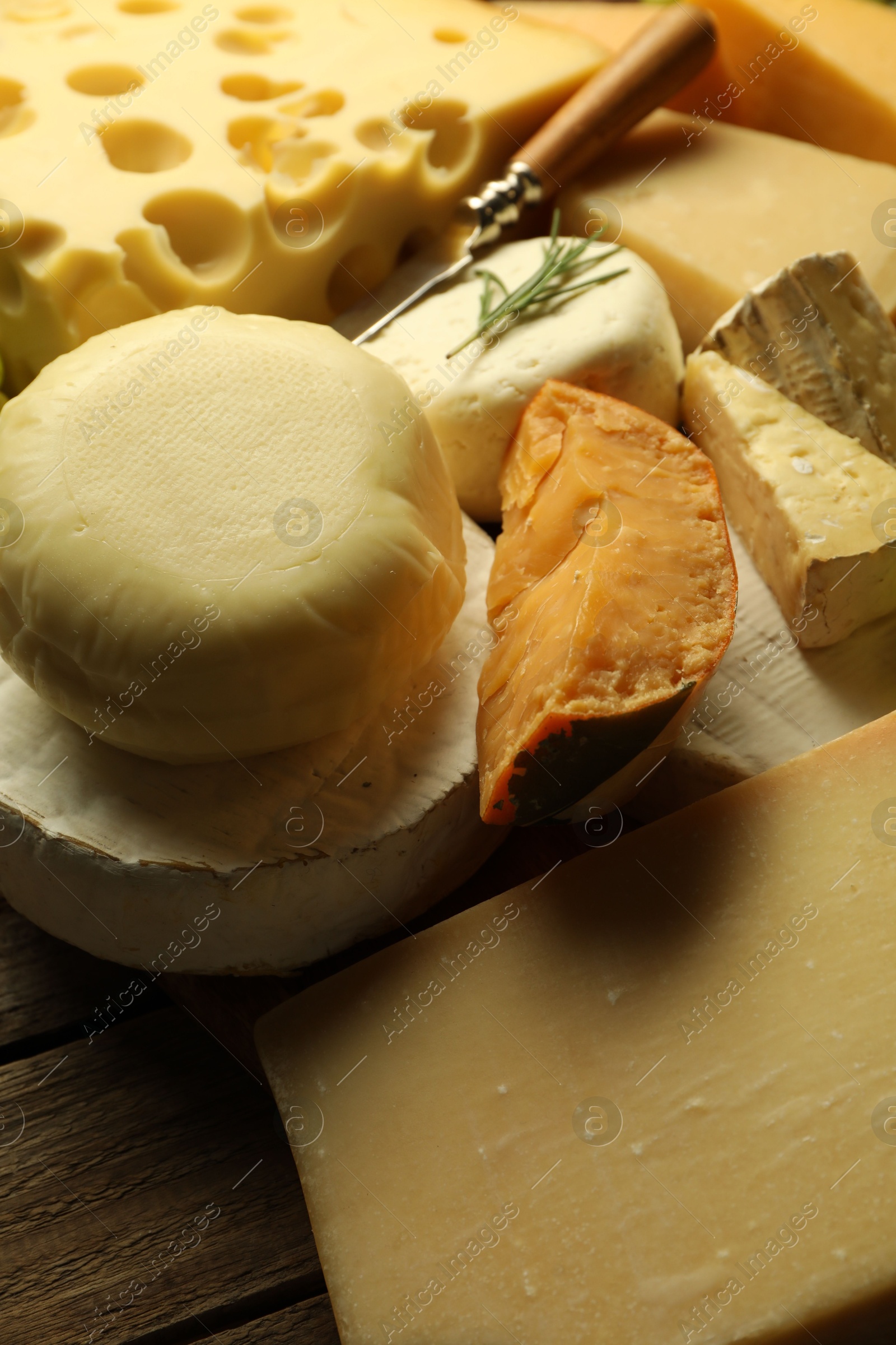 Photo of Different types of cheese on wooden table, closeup