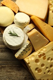 Photo of Different types of cheese on wooden table, top view