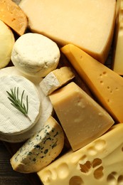 Photo of Different types of cheese on wooden table, flat lay