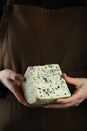 Woman with piece of delicious cheese, closeup