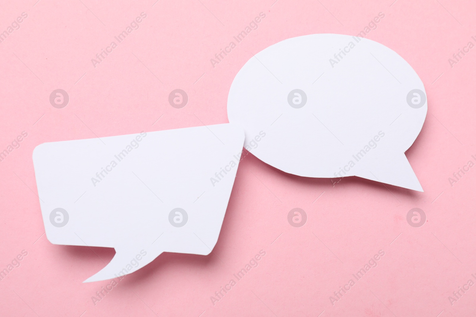 Photo of Blank speech bubbles on light pink background. Space for text