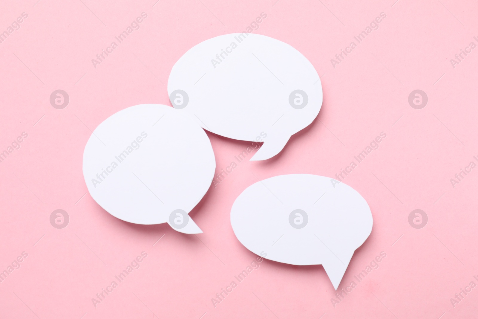 Photo of Blank speech bubbles on light pink background. Space for text