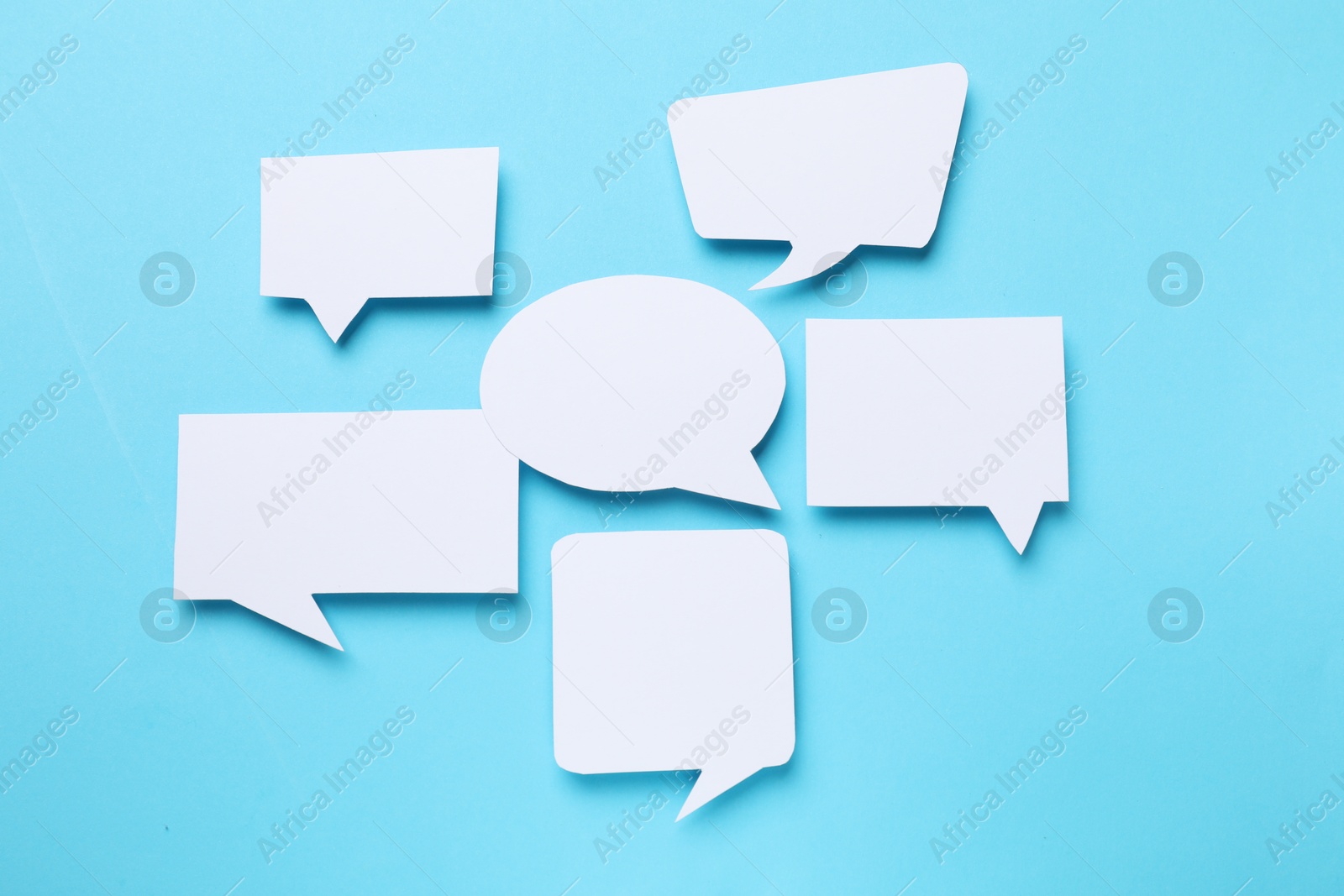 Photo of Blank speech bubbles on light blue background. Space for text