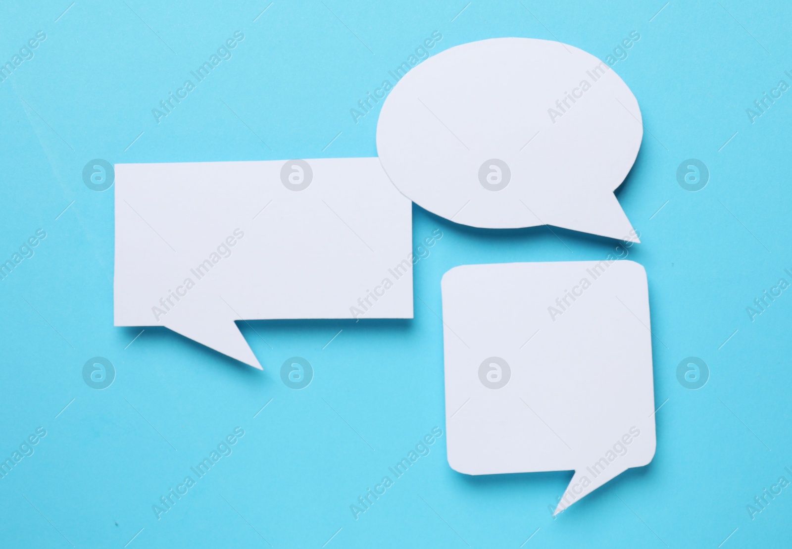 Photo of Blank speech bubbles on light blue background. Space for text